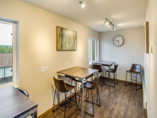 a dining room with tables and chairs and a clock at Campus Park, Duluth