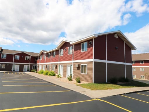 a row of red buildings with a parking lot at Campus Park, Minnesota