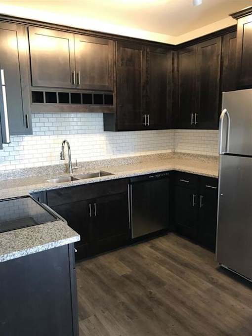 a kitchen with black cabinets and a stainless steel refrigerator at Arbor Ridge, Forest Lake