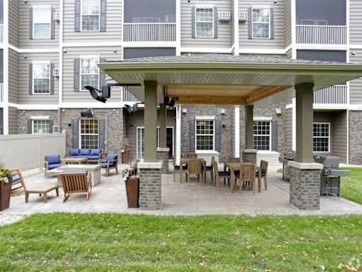 a covered patio with a table and chairs at Arbor Ridge, Forest Lake, Minnesota