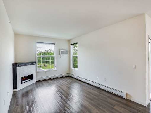 an empty living room with a fireplace and wooden floors at Arbor Ridge, Forest Lake, MN, 55025