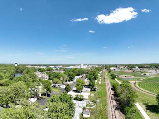 an aerial view of a city with trees and a train track