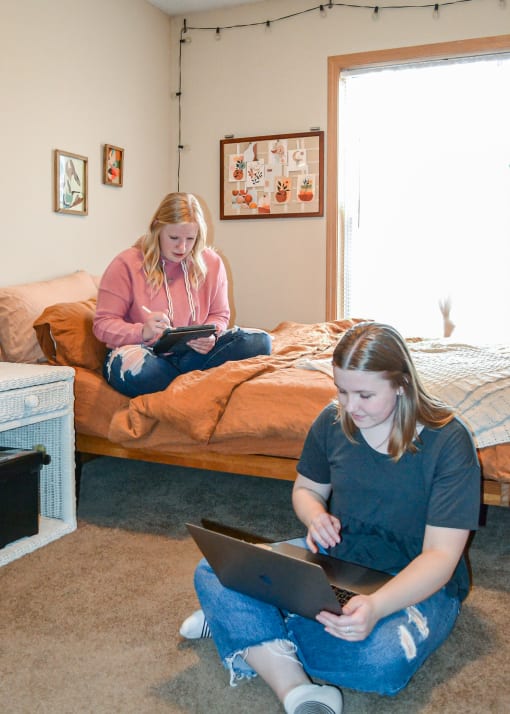 two girls sitting on the floor in a bedroom on their laptops at Summit Ridge, Minnesota, 55811