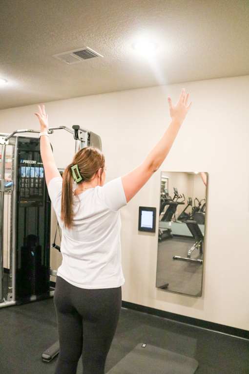 a woman standing in a gym with her arms in the air  at Timber Ridge, Forest Lake, MN, 55025