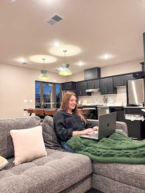 a woman sitting on a couch using a laptop computer  at Timber Ridge, Minnesota, 55025