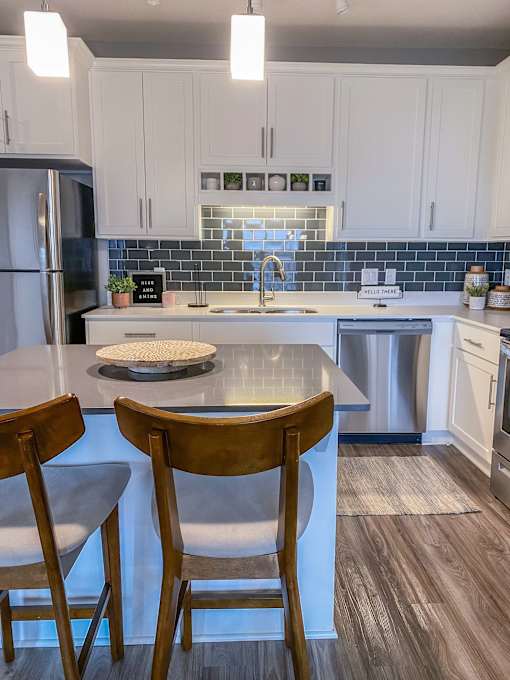 a kitchen with a center island and three stools  at Timber Ridge, Forest Lake