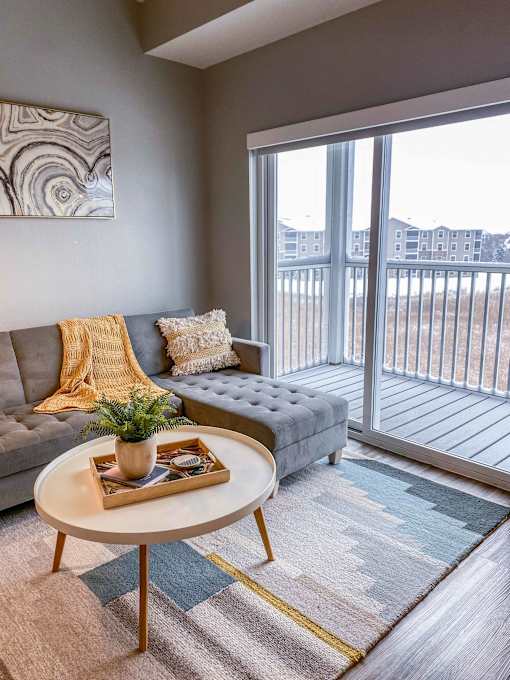 a living room with a couch and a table and a balcony  at Timber Ridge, Forest Lake