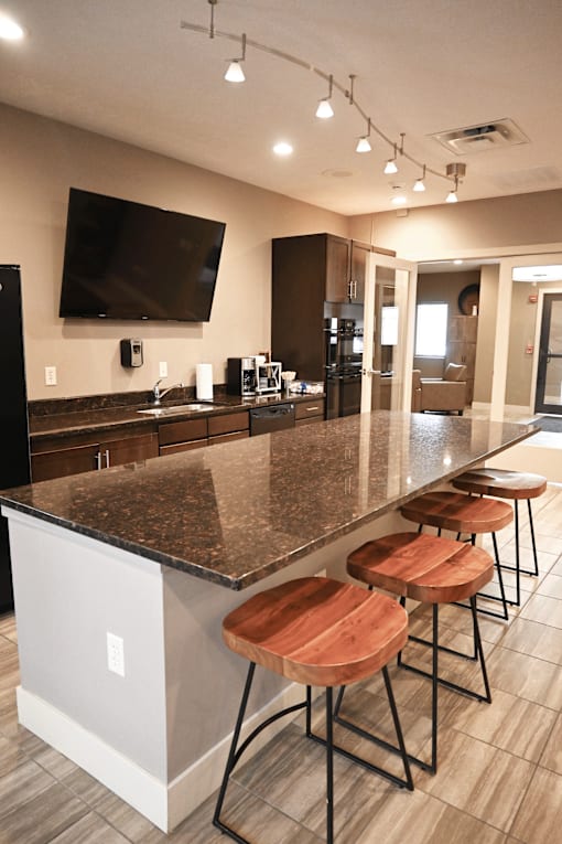 A kitchen with a bar area and stools.