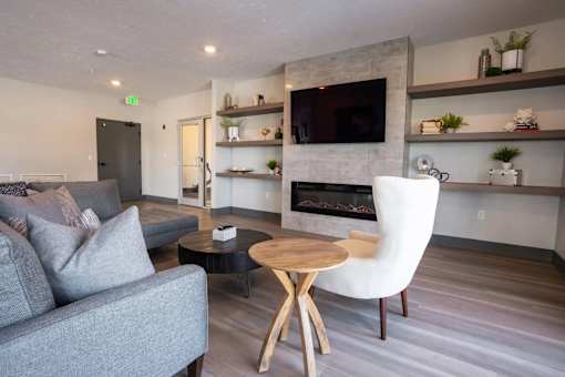 A grey couch sits in front of a fireplace in a modern living room.