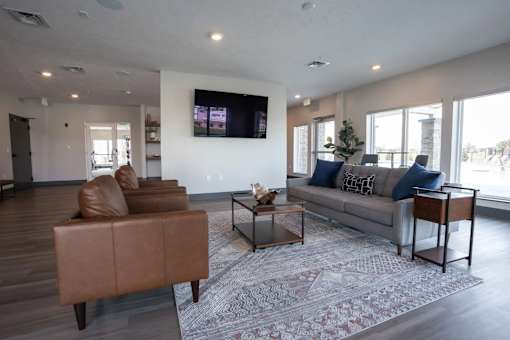 A living room with a brown leather chair and a grey sofa.