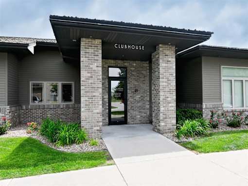 The clubhouse has a glass door and is made of brick.