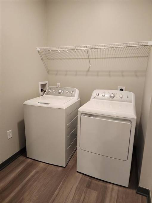 Two white front loading washing machines in a laundry room.