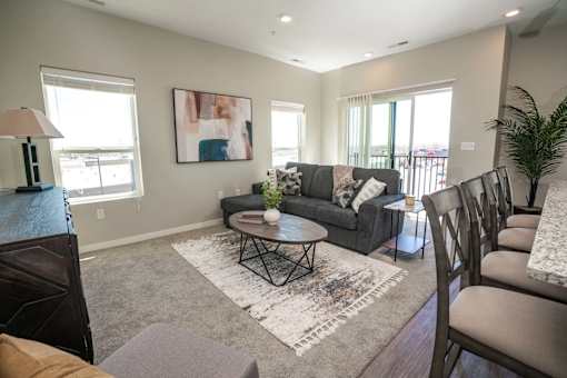 A living room with a grey couch, a coffee table, and a rug with the word "Portland" on it.