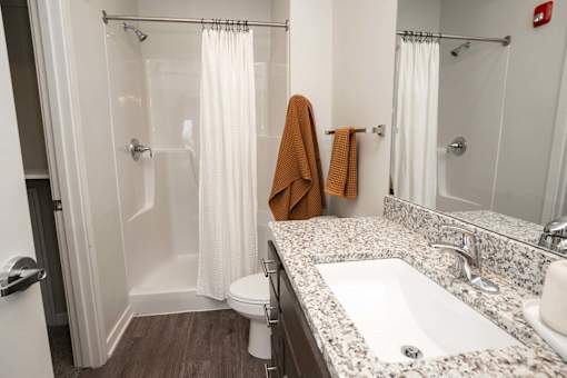 A bathroom with a toilet, sink, and shower.