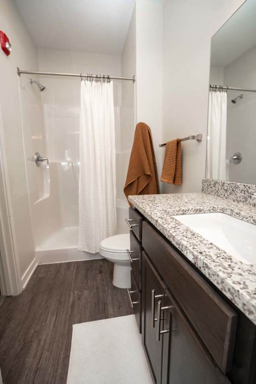 A bathroom with a toilet, sink, and shower.