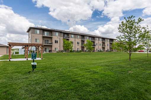 A large grassy area in front of apartment buildings.