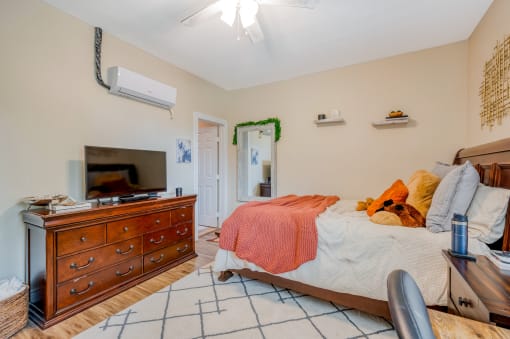 a bedroom with a bed and a dresser and a tv
