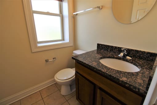 a bathroom with a sink and a toilet and a window