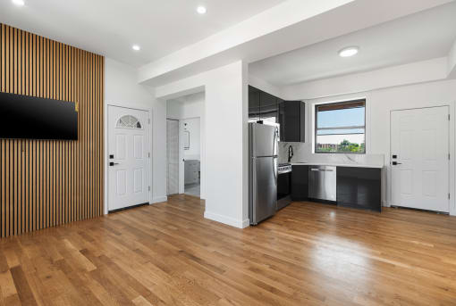 a kitchen with a stainless steel refrigerator and a wooden floor