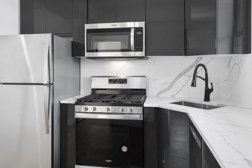 a black and white kitchen with a stove and a microwave