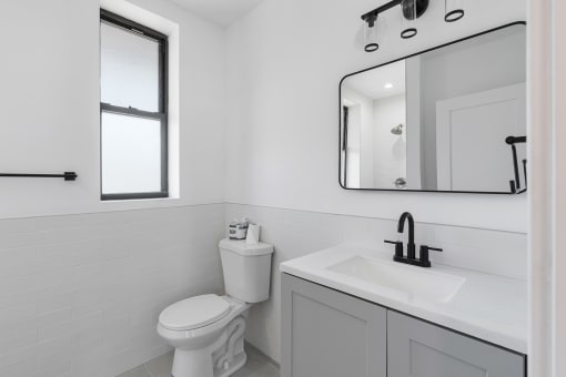 a white bathroom with a toilet and a sink