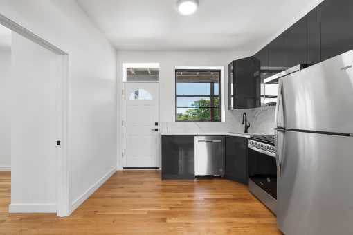a renovated kitchen with stainless steel appliances and black cabinets