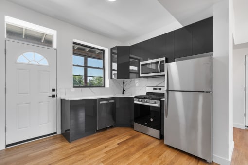 a kitchen with stainless steel appliances and black cabinets