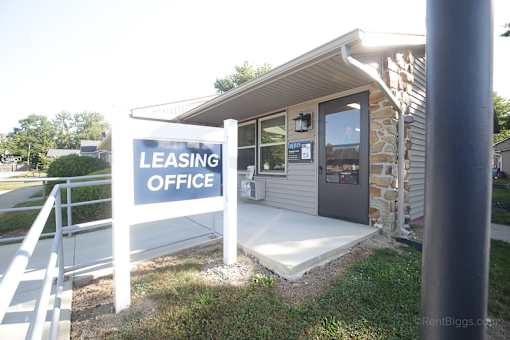 A leasing office is located in a small building with a stone wall.