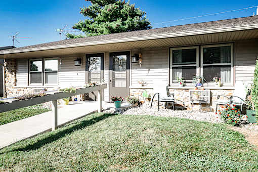 A house with a white fence and a green lawn.