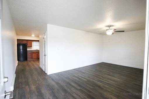 A room with a ceiling fan and wooden flooring.