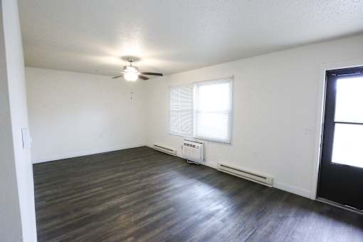 A room with a ceiling fan and a window with blinds.