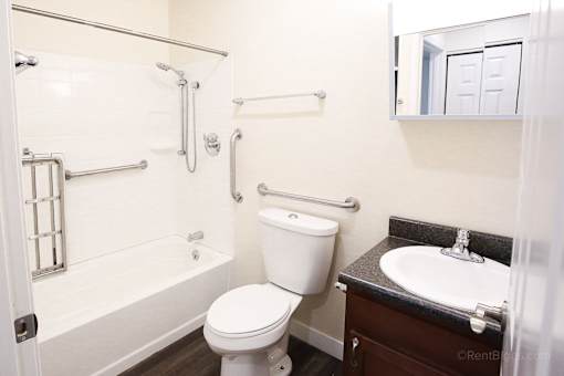 A white toilet sits next to a sink in a bathroom.
