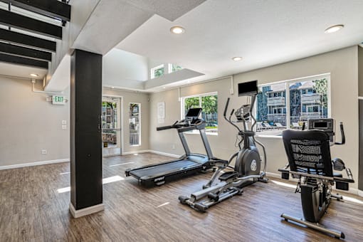 A gym with treadmills, elliptical machines, and a stationary bike.