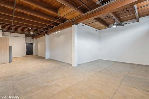 A large empty room with wooden ceiling and tiled floor.