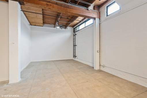 A room with a wooden ceiling and a window on the right side.
