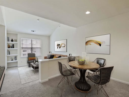 A dining room with a round table and chairs.