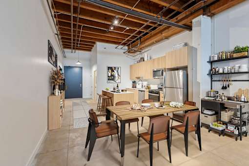 A kitchen with a dining table and chairs.