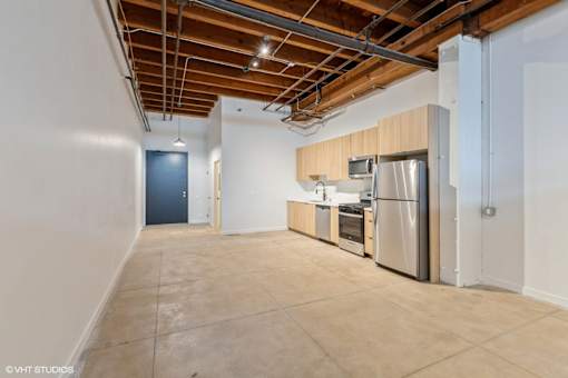 A kitchen area with a stainless steel refrigerator, microwave, and oven.