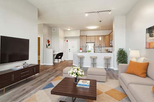 A modern living room with a flat screen TV, a coffee table, and a couch.