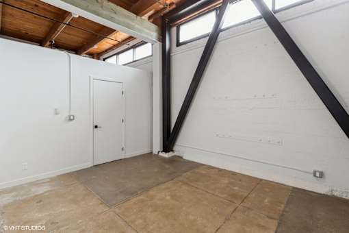 A room with a white wall and a brown floor.
