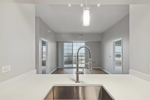 A modern kitchen with a stainless steel sink and a large window.