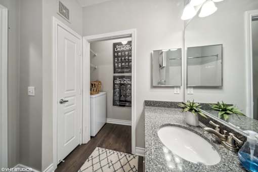 A bathroom with a white sink and a mirror.