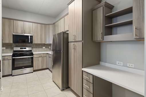 A kitchen with a refrigerator, oven, and microwave.
