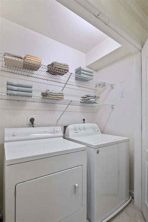 a white laundry room with two washes and a dryer