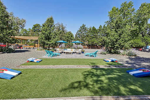 A sunny day at a park with a playground and picnic tables.