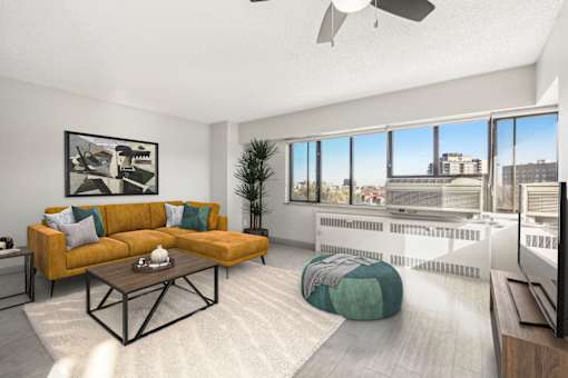 Spacious living area with a wall of windows and a ceiling fan