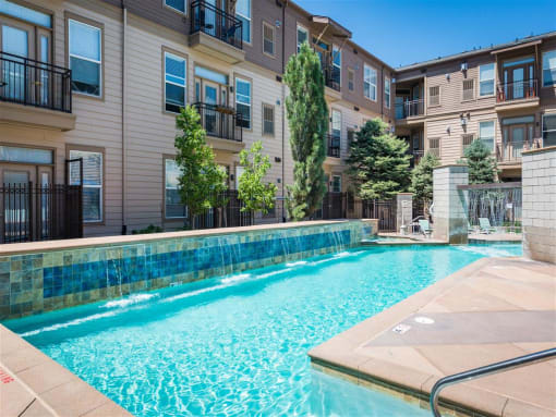 a swimming pool with an apartment building in the background