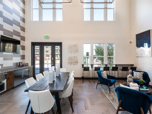 a dining room with a table and chairs and a living room with high ceilings