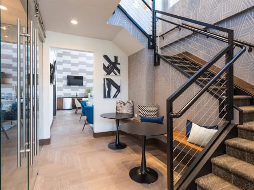 a living room with a staircase and a glass door