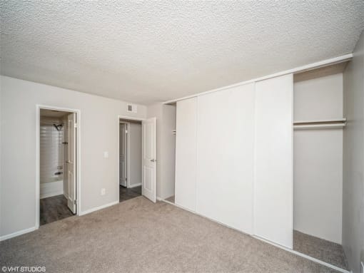 Bedroom with white walls and closet doors  at Avery Park in Englewood, CO